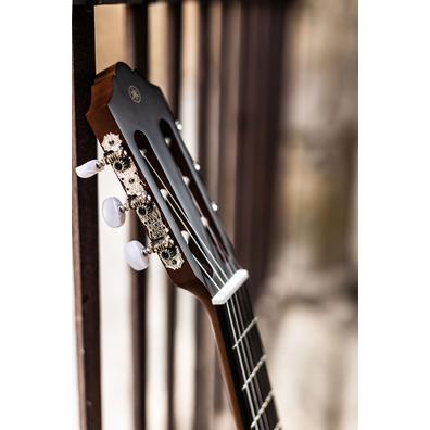 Headstock, tuning machines for  CGX122 guitar leaning on a metal fence in Spain 