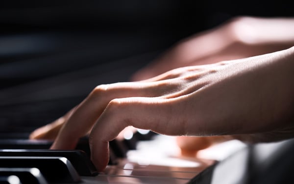 Hand playing the keys of CLP piano