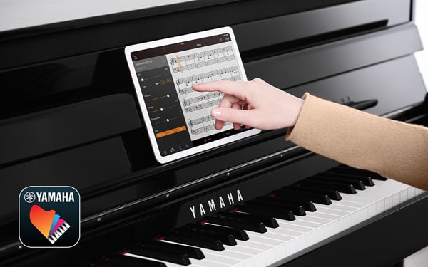 Hand browsing the tablet on top the Piano