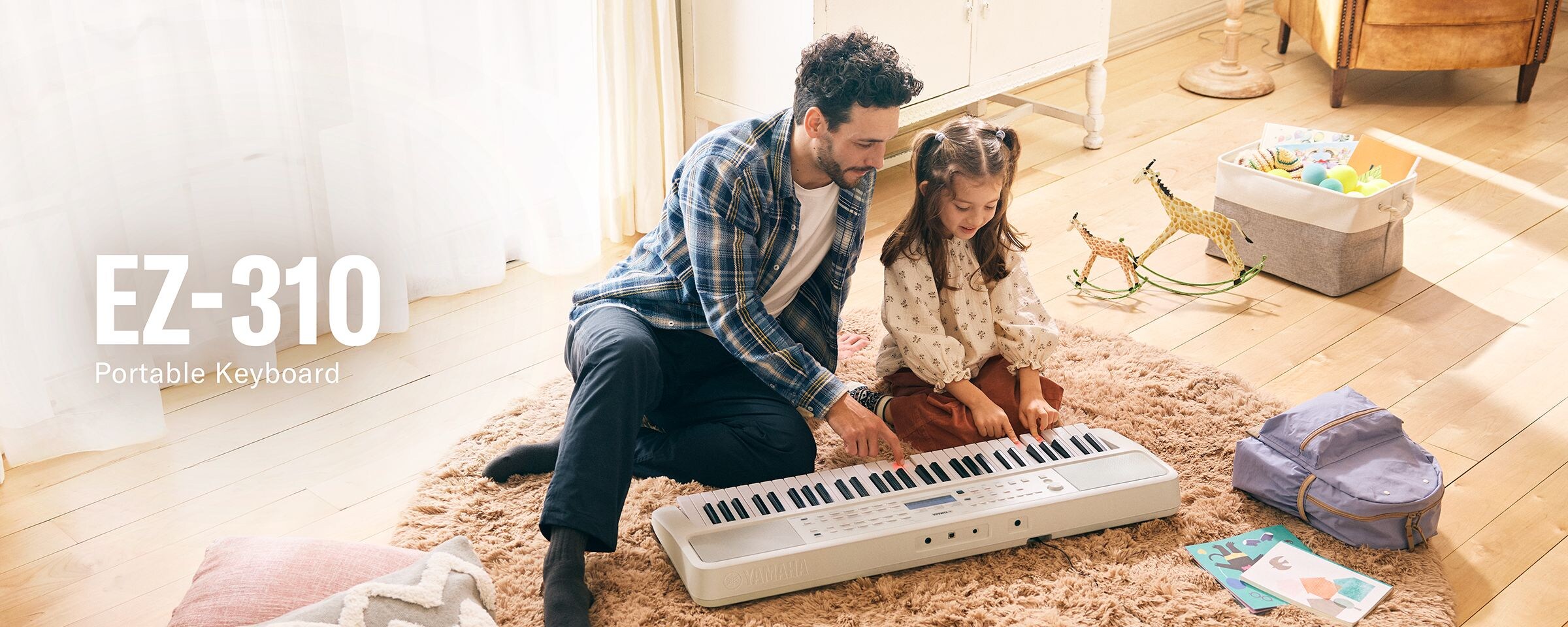 Father and daughter happily playing the EZ-310 on the floor.