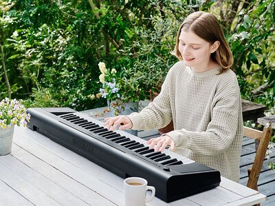 A person playing the Piaggero outdoors without a power source, using the Piaggero’s battery power