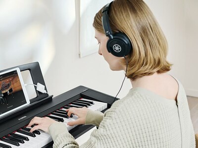 A person using headphones while practicing on the Piaggero