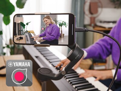 A view of the Yamaha Rec'n'Share app icon and a person taking a smartphone video of them playing