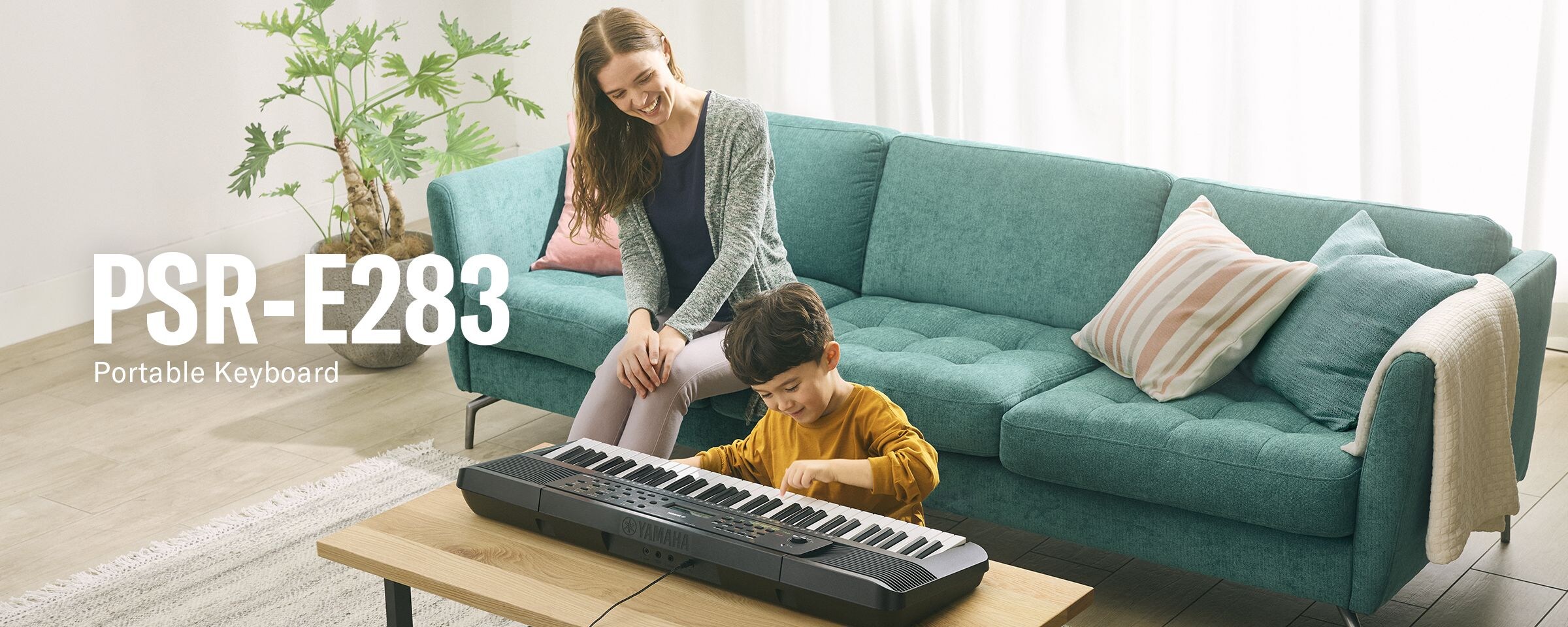 Parent and child happily playing the PSR-E283 on the table