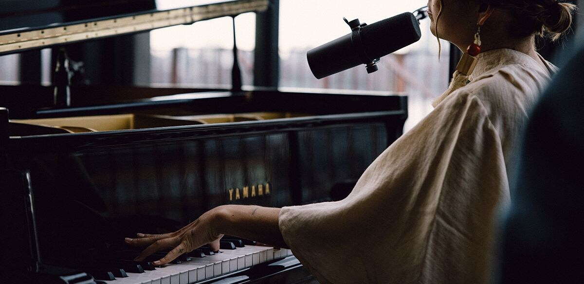 Person playing a Yamaha grand piano.