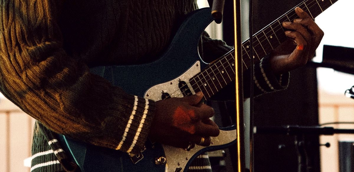 Person playing a Yamaha electric guitar.