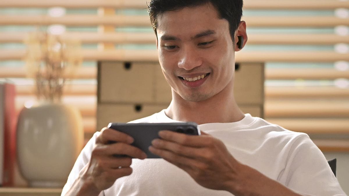 Image showing a man wearing TWEF3A Earbuds and holding a phone