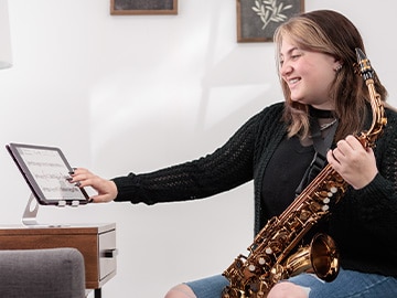 image of a female holding Yamaha Saxohphone