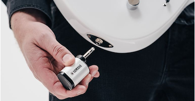 A man about to plug a YW10T wireless transmitter into the output jack of an electric guitar