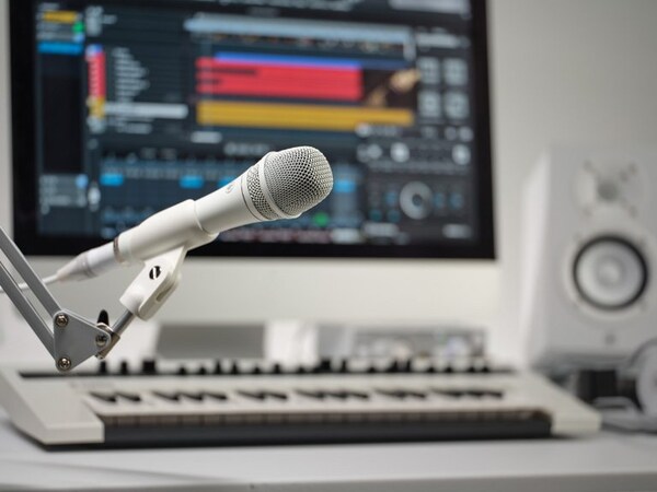 The Yamaha YDM707 microphone placed on a holder and a home studio in the background.