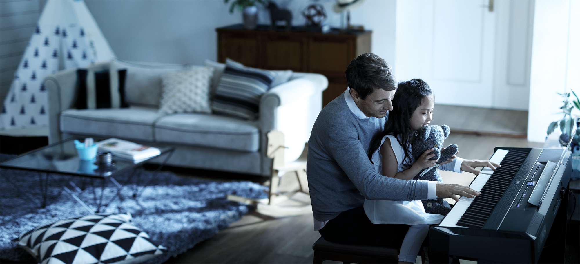 father and daughter playing p-515 piano in a living room