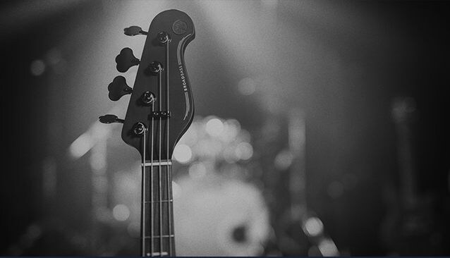 Close-up of BB headstock with soft focus on a drumkit in the background