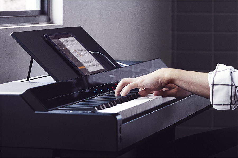 A Yamaha P-S500 and a smart device displaying a music score using the Smart Pianist app