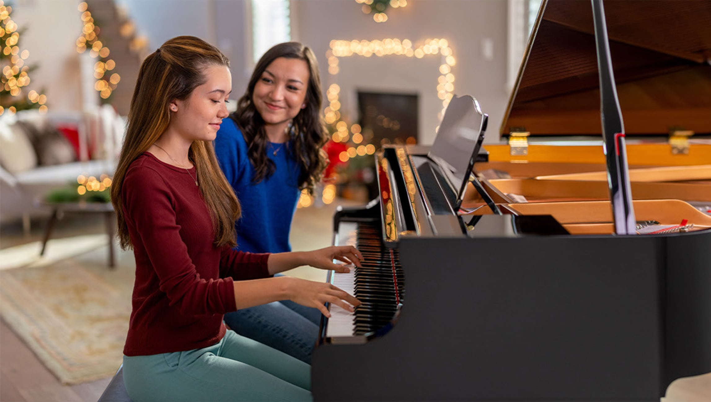 happy mother with daughter playing the piano 